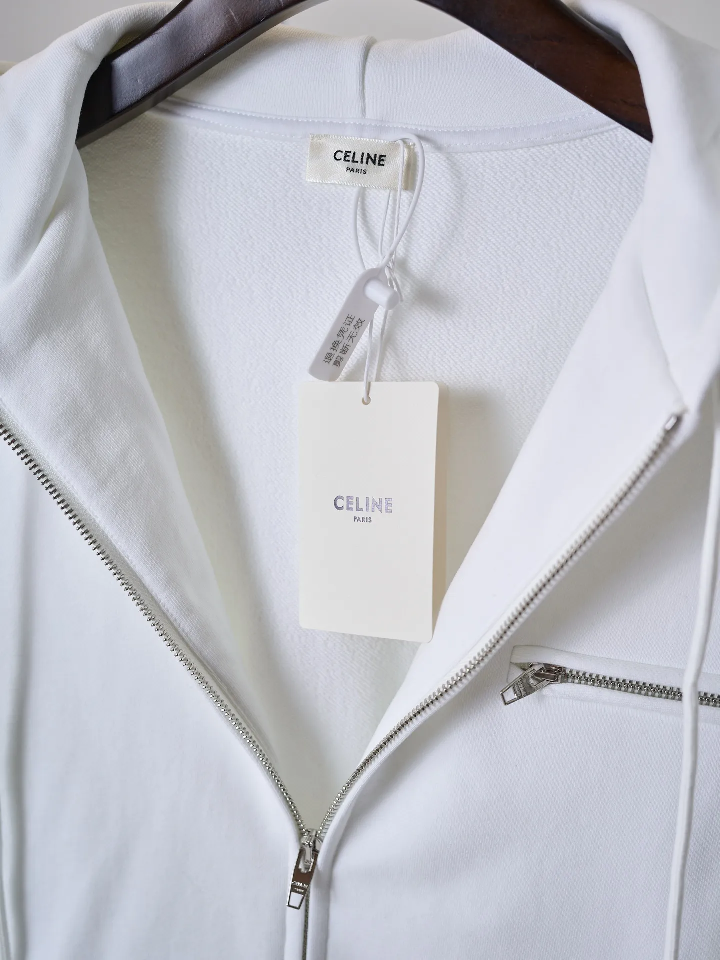 [Real auction] Celine/Celine logo embroidered zipper jacket (women's style) [In Stock] S M L custom-made light oxygen cotton-feel fleece knit, delicate and smooth, soft and skin-friendly. The body is laid out in clear white, with a soft cotton-like texture and rich layers. The elegant white tone brings a refreshing and clean daily atmosphere. The iconic Celine Arc de Triomphe embroidery is embellished on the chest, which is simple yet memorable. The simple hoodie silhouette sets a refreshing tone, and the two-way metal zipper design is full of texture. The short silhouette with loose, dropped shoulders gently modifies the lines of the shoulders and arms; the drawstring at the hem is adjustable to shape the silhouette as desired, and the short length optimizes body proportions. The simple silhouette carries a lazy atmosphere, and the relaxed outfit reveals the French girlish attitude. 1. Imported machine embroidery technology uses advanced computer control systems and precision mechanical components to precisely create the iconic TRIOMPHE logo embroidery, with smooth and delicate lines and a full sense of sophistication. 2. Fermentation washing treatment: The fabrics have been fermentation washing, which makes the hand feel and texture better, is not easy to deform, shrink, and fade, and maintains long-term beauty and loose fit.
